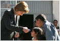 Laura Bush hands red, white and blue kaleidoscopes to youngsters outside a Kabul bakery Wednesday, March 30, 2005 during her visit to Afghanistan.