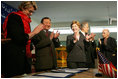 Laura Bush applauds as Secretary of Education Margaret Spellings and Afghan Minister of Education Noor Mohammas Qarqeen complete the signing of the Memorandum of Understanding for funds to build a university in Kabul, Afghanistan Wednesday, March 30, 2005.