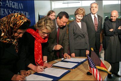 Laura Bush observes as Secretary of Education Margaret Spellings and Afghan Minister of Education Noor Mohammas Qarqeen complete the signing of the Memorandum of Understanding for funds to build a university in Kabul, Afghanistan Wednesday, March 30, 2005.