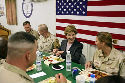 Laura Bush laughs with troops as they eat dinner in the Dragon Chow Dining Hall on Bagram Air Base in Kabul, Afghanistan Wednesday, March 30, 2005.