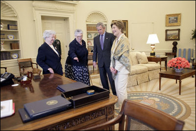 President George W. Bush and Laura Bush discuss some of the history of the Oval Office Agnes Chouteau, left, and Lorraine Stange both of Missouri Monday, May 2, 2005. The two women are recipients of the 2005 Preserve America Presidential Award.