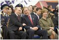 President George W. Bush and Russian President Vladimir Putin share a light moment as they sit with Laura Bush and other heads of state during a military parade marking the end of World War II in Moscow's Red Square, Monday, May 9, 2005.