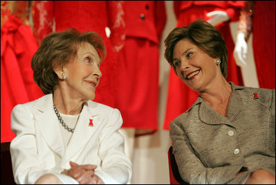 Laura Bush and former First Lady Nancy Reagan share a moment Thursday, May 12, 2005, at the John F. Kennedy Center for the Performing Arts during the unveiling of The Heart Truth’s First Ladies Red Dress Collection.