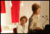 With former First Lady Nancy Reagan looking on, Laura Bush addresses the opening of The Heart Truth’s First Ladies Red Dress Collection Thursday, May 12, 2005, at the John F. Kennedy Center for the Performing Arts in Washington D.C. Mrs. Bush, the ambassador for The Heart Truth, wore her red Carolina Herrera suit to the Bolshoi Theater in Moscow and to The Heart Truth’s Red Dress Collection Fashion Show 2005 in New York City.