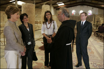 Laura Bush talks with Father Michele Piccirillo, head of the Franciscan Archeology Society, Chief of Staff Anita McBride, second on left, and Queen Rania al-Abdullah, center, in the Basillica on top of Mount Nebo in Jordan Saturday, May 21, 2005.