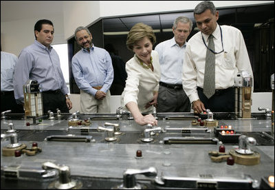 Laura Bush with President George W. Bush turns a knob during a tour of the operations center of the Panama Canal's Miraflores Locks in Panama City, Panama, Monday, Nov. 7, 2005.