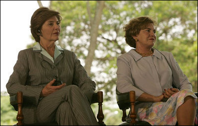 Mrs. Laura Bush and Mrs. Marisa Leticia da Silva listen to remarks by their husbands, during a joint statement at Granja do Torto, home of Brazil President Luiz Inacio Lula da Silva, Saturday, Nov. 6, 2005.