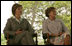 Mrs. Laura Bush and Mrs. Marisa Leticia da Silva listen to remarks by their husbands, during a joint statement at Granja do Torto, home of Brazil President Luiz Inacio Lula da Silva, Saturday, Nov. 6, 2005.