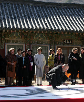 A calligrapher at the Beomeosa Temple in Busan entertains the spouses of APEC leaders Friday, Nov. 18, 2005, during the two-day summit.