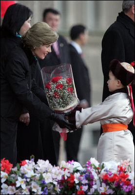 A young boy delivers a bouquet of flowers to Mrs. Bush Monday, Nov. 21, 2005, as she and President Bush joined Mongolia's President and First Lady in ceremonies in Ulaanbaatar welcoming the Bushes to Mongolia.