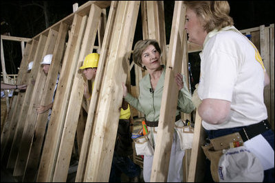 Laura Bush helps push a support wall into place, Tuesday, Oct. 11, 2005, while visiting a Habitat for Humanity building site in Covington, La., where homes are being built for victims of Hurricane Katrina.