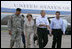 President George W. Bush and Laura Bush walk with Lt. General Russel Honore, left, and Plaquemines Parish president Benny Rousselle, right, upon their arrival Monday, Oct. 10, 2005 at the U.S. Naval Air Station, Joint Reserve Base in New Orleans, La.