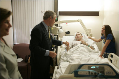 President George W. Bush shakes the hand of SPC Jeremy Goodman of Washington, N.C., as his wife, Terry Goodman, looks on Wednesday, Oct. 5, 2005, during a visit by the President and Mrs. Bush to Walter Reed Army Medical Center in Washington D.C.