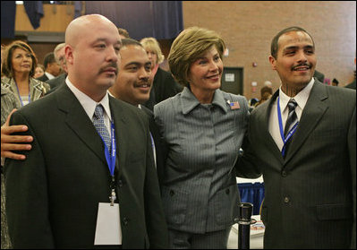 Laura Bush poses for photos with Homeboy Industries representatives, Gustavo Mojica, Herbert Corleto and Gabriel Hinojos, Thursday, Oct. 27, 2005 at Howard University in Washington, at the White House Conference on Helping America's Youth.