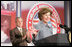 President George W. Bush, background, applauds as Mrs. Bush offers her welcoming remarks, Thursday, Oct. 27, 2005 at Howard University in Washington, at the White House Conference on Helping America's Youth.