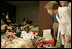 Laura Bush leans down to comfort a woman and her young child inside the Cajundome at the University of Louisiana in Lafayette, Friday, Sept. 2, 2005, during her visit to the center, one of many created to accommodate victims of Hurricane Katrina.