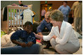 Laura Bush visits with a young boy displaced by Hurricane Katrina in the Cajundome at the University of Louisiana in Lafayette, La., Friday, Sept. 2, 2005.