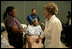 Laura Bush reaches out to a victim of Hurricane Katrina during a visit Friday, Sept. 2, 2005, to the Cajundome at the University of Louisiana in Lafayette. "The people of this part of the United States, the Lafayette area of Louisiana, are very, very warm people," said Mrs. Bush. "They've opened their hearts, and many of them have opened their homes, as well, to people from New Orleans -- family members and strangers."