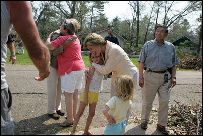 Laura Bush visits with a family outside their hurricane damaged home, Monday, Sept. 5, 2005, on West Ida Street in Poplarville, Miss. President George W. Bush and Mrs. Bush made the visit during their trip through the hurricane ravaged areas of the Gulf Coast.