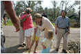 Laura Bush visits with a family outside their hurricane damaged home, Monday, Sept. 5, 2005, on West Ida Street in Poplarville, Miss. President George W. Bush and Mrs. Bush made the visit during their trip through the hurricane ravaged areas of the Gulf Coast.