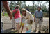 Laura Bush visits with a family outside their hurricane damaged home, Monday, Sept. 5, 2005, on West Ida Street in Poplarville, Miss. President George W. Bush and Mrs. Bush made the visit during their trip through the hurricane ravaged areas of the Gulf Coast.