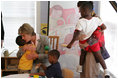 Mrs. Laura Bush receives a hug from a young boy at the House of Tiny Treasures in Houston during her visit Monday, Sept. 19, 2005. The House enables parents to search for jobs and housing, and to run errands while their children receive good care from credentialed teachers.