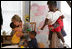 Mrs. Laura Bush receives a hug from a young boy at the House of Tiny Treasures in Houston during her visit Monday, Sept. 19, 2005. The House enables parents to search for jobs and housing, and to run errands while their children receive good care from credentialed teachers.