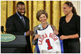 Golden State Warrior Baron Davis, left, and Phoenix Mercury guard Diana Taurasi, right, present Laura Bush with a basketball jersey at the National Book Festival Author's breakfast in the East Room Saturday, Sept. 24, 2005.