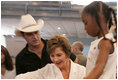 Laura Bush meets with people while visiting a clothing distribution site at the Biloxi Community Center, Tuesday, Sept. 27, 2005 in Biloxi, Miss., where she also interviewed with the television program, ABC's Extreme Makeover: Home Edition.