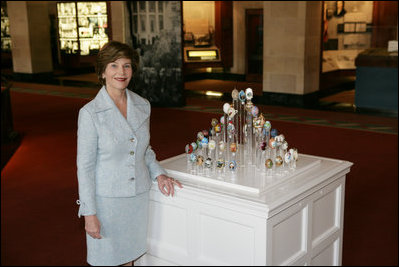 Mrs. Laura Bush poses for a photo next to the State Egg Display which exhibits a decorated egg from a select artist of each state Thursday, April 6, 2006, at the White House Visitor Center. This tradition has been going on since 1994, and each year the artists vote amongst themselves to select the artist to create the following year's commemorative egg which is presented to the President and First Lady.