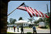 President George W. Bush waves as he is joined by Biloxi Mayor A.J. Holloway, left, Monday, Aug. 28, 2006, during President Bush's walking tour in the same Biloxi, Miss., neighborhood he visited following Hurricane Katrina in September 2005. The tour allowed President Bush the opportunity to assess the progress of the area's recovery and rebuilding efforts following the devastating hurricane.