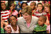 Mrs. Laura Bush embraces two students Monday, Aug. 28, 2006, as she meets and speaks with members of the Gorenflo Elementary School first grade class in their temporary portable classroom at the Beauvoir Elementary School in Biloxi, Miss. The students, whose school was damaged by Hurricane Katrina, are sharing the facilities of the Beauvoir school until their school’s renovations are complete.