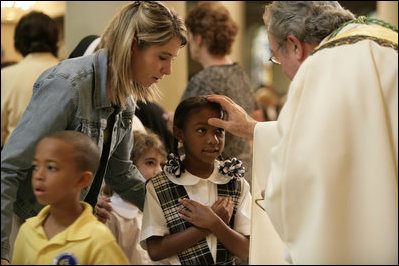 A young girl receives a blessing during a memorial Mass attended by President George W. Bush and Laura Bush at St. Louis Cathedral in New Orleans, Tuesday morning, Aug. 29, 2006, to commemorate the one- year anniversary of Hurricane Katrina.