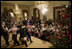 President George W. Bush and Mrs. Laura Bush sit with children of deployed U.S. military personnel and watch a performance of "Willy Wonka" by members of The Kennedy Center Education Department in the East Room Monday, Dec. 4, 2006.