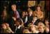 President George W. Bush and Mrs. Laura Bush sit with children of deployed U.S. military personnel and watch a performance of "Willy Wonka" by members of The Kennedy Center Education Department in the East Room Monday, Dec. 4, 2006. 