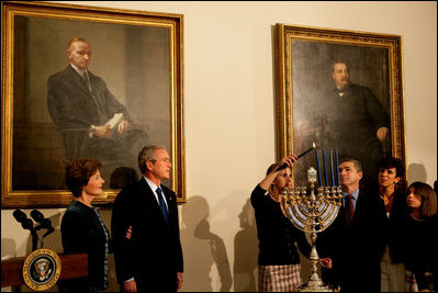 President George W. Bush and Laura Bush watch as Ariel Cohen, 14, lights the Menorah on the fourth night of Hanukkah during the annual White House Hanukkah reception Monday, Dec. 18, 2006. Pictured at right are Ariel's parents, Dan and Rachel Cohen, and sister Alison, 11.