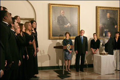 President George W. Bush and Laura Bush listen to Indiana University's A Cappella Choir, HooShir, sing during the lighting of the Menorah during the annual White House Hanukkah reception Monday, Dec. 18, 2006. Pictured at right is Ariel Cohen, 14, and her parents Dan and Rachel Cohen.