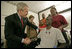 President George W. Bush shakes the hand of SSgt. Marcus Wilson after awarding him two Purple Hearts at the Walter Reed Army Medical Center in Washington, D.C., Friday, Dec. 22, 2006, as Mrs. Laura Bush and members of the Marine's family look on. Wilson, who is from Dermott, Arkansas, is recovering from wounds suffered in Operation Iraqi Freedom. 