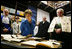 Laura Bush looks at books dating to the 1500’s during a tour of the Ancient Library at the University of Turin guided by Paolo Novaria, Archives, left, and Enrico Artifoni, right, Saturday, Feb. 11, 2006, in Turin, Italy.