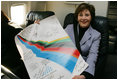 Mrs. Laura Bush shows her signatured 2006 Winter Olympic poster during her flight home from Italy, Feb. 12, 2006.