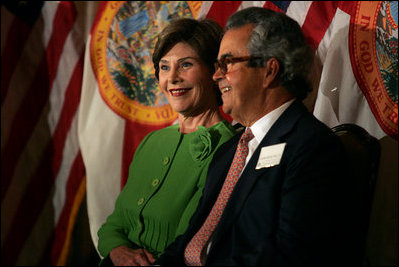 Laura Bush sits with Carlos del la Cruz, Event Host, during a Junior Ranger event Wednesday, Feb. 15, 2006, in Coral Gables, FL. The Junior Ranger programs introduces young people to America's national parks and historic sites, and is operating in 286 of the 388 National Parks across the country.