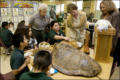 Laura Bush, listens to a student talk about Sea Turtles, Thursday, Feb. 16, 2006, as Fran Mainella, Director of the National Park Service, and Stella Summers, Teacher of the Gifted Science class, look on during a visit to Banyan Elementary School in Miami, FL, to support education about parks and the environment.