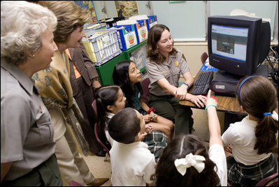 Laura Bush and Fran Mainella look on as students of Stella Summer’s Gifted Science class work with Ranger Maria Beotegui Thursday, Feb. 16, 2006, to navigate through Web Rangers, the online version of Junior Rangers, during a visit to Banyan Elementary School in Miami, FL. The National Junior Ranger Programs promote knowledge of science, history, the environment and learning through fun.