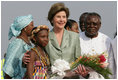 Mrs. Laura Bush stands with 10-year-old Aisha Garuba Sunday, Jan. 15, 2006, after she presented Mrs. Bush with flowers upon her arrival at Kotoka International Airport in Accra, Ghana.