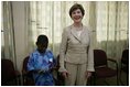 Mrs. Laura Bush stands with a young boy as she visits with patients, their family members and staff at the Korle-Bu Treatment Center, Tuesday, Jan. 17, 2006 in Accra, Ghana.