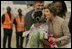 Mrs. Laura Bush embraces 11-year-old Jamila Ahmed after she presented flowers to Mrs. Bush, Tuesday, Jan. 17, 2006, upon her arrival to Abuja, Nigeria. Deputy Chief of U.S. Mission Thomas Fuery and Nigeria's Minister of Education Chinwe Obaji, are seen in the background.