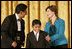 Laura Bush congratulates Jose Fernando Salas, left, and Carlos Gabriel Pascual from the Art and Children Program of Veracruz, Mexico, at their award presentation Wednesday, Jan. 25, 2006 in the East Room of the White House, during the President's Committee on the Arts and the Humanities 2006 Coming Up Taller Awards ceremony.