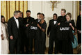 President George W. Bush and Mrs. Laura Bush hold jackets they were given by Special Olympics athletes after they listened to the band Rascal Flatts in the East Room of the White House following a dinner honoring the Special Olympics and founder Eunice Kennedy Shriver, Monday, July 10, 2006.