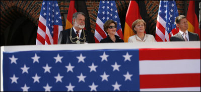 Mrs. Laura Bush is seated between Stralsund Mayor Harald Lastovka and German Chancellor Angela Merkel during the welcoming ceremony Thursday, July 13, 2006, in honor of the visit by President George W. Bush and Laura Bush to Stralsund, Germany.