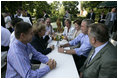 President George W. Bush shares a conversation with Chancellor Angela Merkel of Germany as he and Mrs. Laura Bush enjoy a barbeque dinner in Trinwillershagen as guests of the Chancellor.